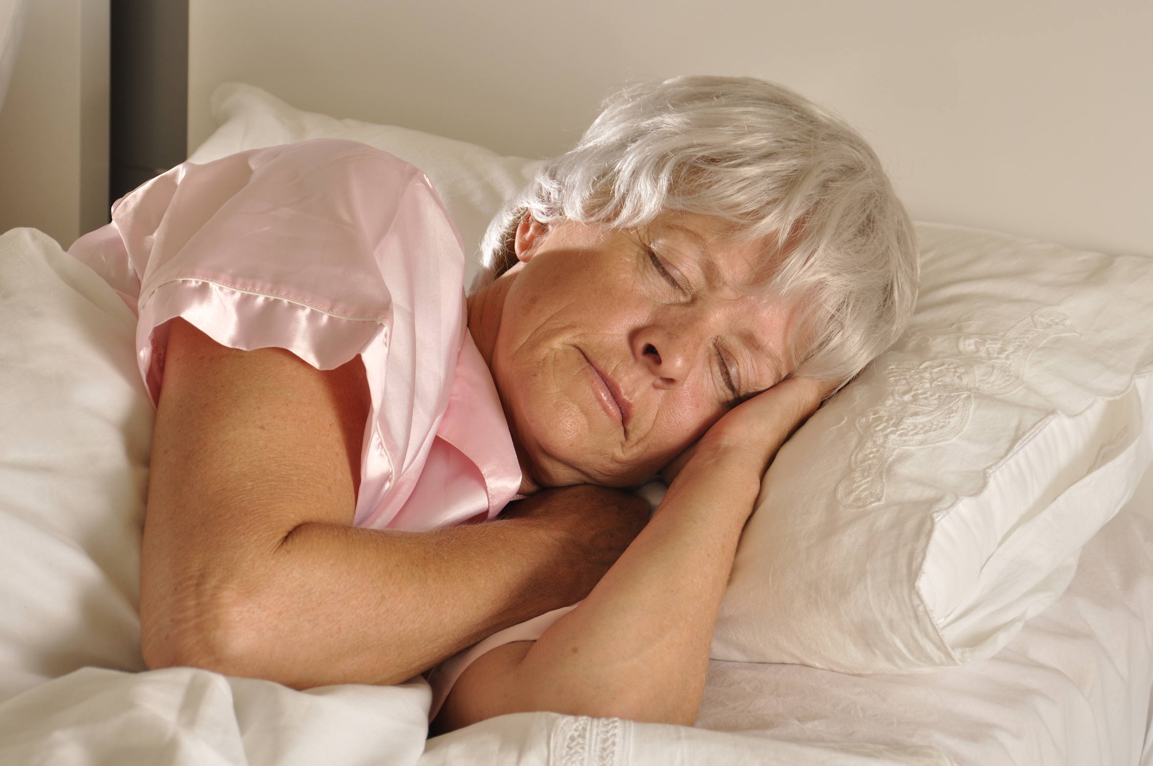 Seniorin schläft in einem Bett